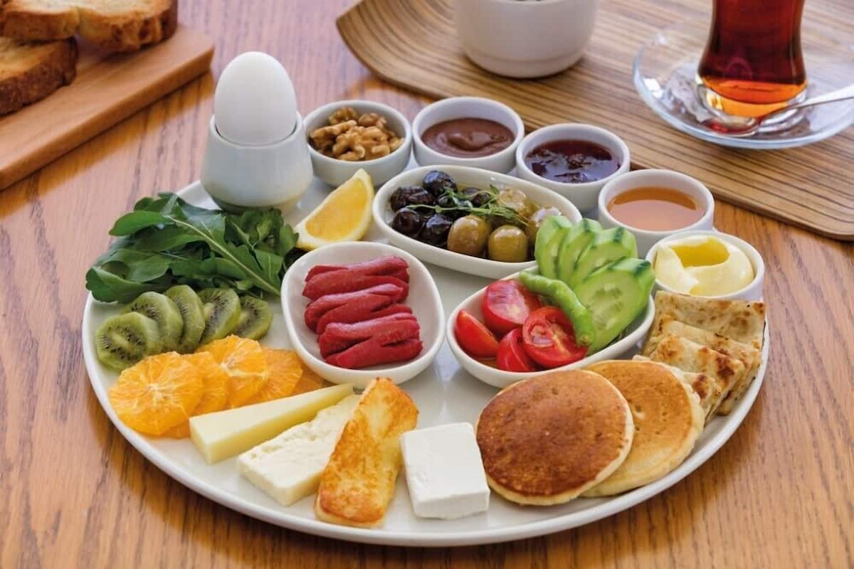 A breakfast plate with various foods and drinks.
