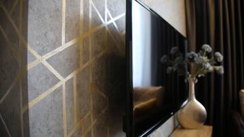 A flat-screen TV mounted on a wall with a geometric patterned design.
