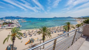 A coastal view with a beach, palm trees, and boats. - Vistamar IV frontline sea Apt. in a prime location in Puerto Pollensa (Puerto Pollensa)