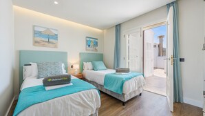 A hotel room with two beds, a balcony, and a view of the sea. - Vistamar IV frontline sea Apt. in a prime location in Puerto Pollensa (Puerto Pollensa)