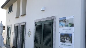 A building with checkered flooring, green shutters, and a sign advertising a B&B. - Borgo San Biagio (Calatabiano)