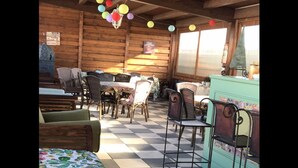 A rustic wooden interior with a checkered floor, wicker furniture, and a green cabinet. - Borgo San Biagio (Calatabiano)