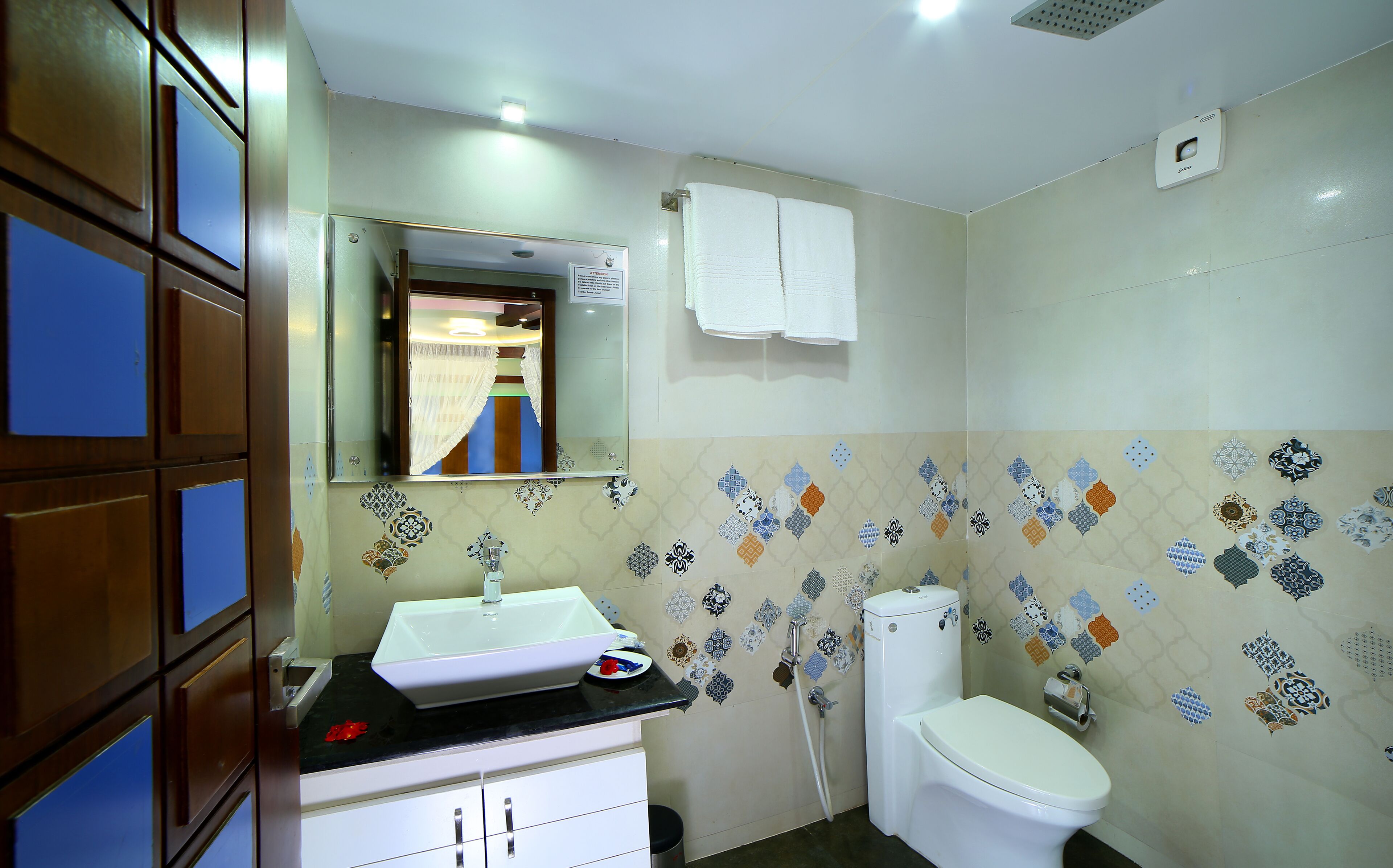 Een badkamer met een wastafel, toilet en spiegel.