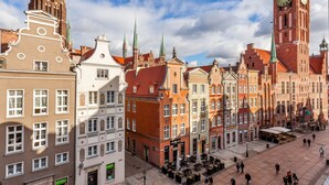 A historic square with traditional European architecture, including a prominent clock tower and a variety of buildings with distinct facades. - Frey Homes Gdansk Old Town (Gdansk)