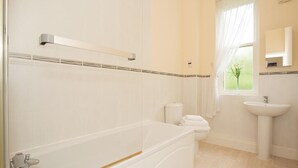 Ein modernes Badezimmer mit Badewanne, Toilette und Waschbecken.