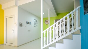A hallway with a white door, a wall with motivational quotes, and a staircase with white railings. - Anonymous - 2BR - 2Floors - Central (Ayia Napa)