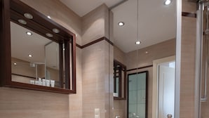 Een moderne badkamer met twee wastafels, een grote spiegel en een douchecabine van glas.