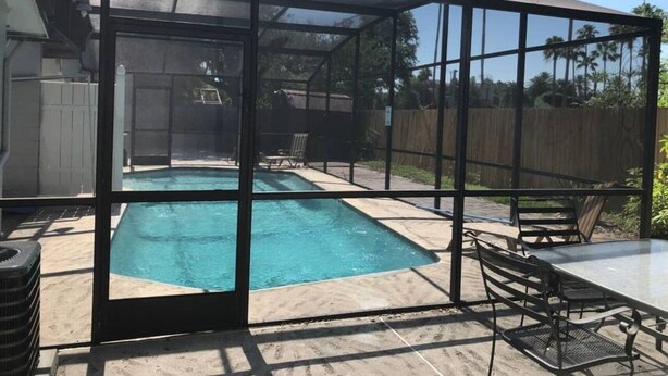 Ein Garten mit Schwimmbad, überdachtem Patio und Gartenmöbeln.