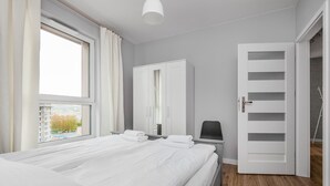 Ein Schlafzimmer mit einem großen Bett, einem Kleiderschrank, einem Schreibtisch und einem Stuhl.