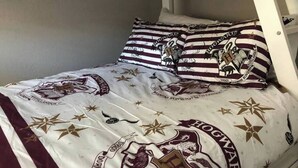 A bed with a Hogwarts-themed duvet and pillows. - 6151 Sandcrest · Next to Universal. Pool Sleep 9. Walk to Park (Orlando)