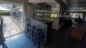 Una cocina moderna con barra, ventanas amplias y un patio.