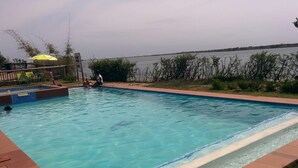 A rectangular swimming pool with clear blue water, surrounded by a tiled deck. - Macaneta Holiday Resort (Marracuene)
