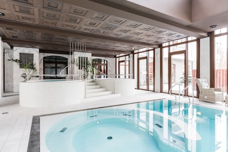 Una piscina techada, sillones reclinables de piscina