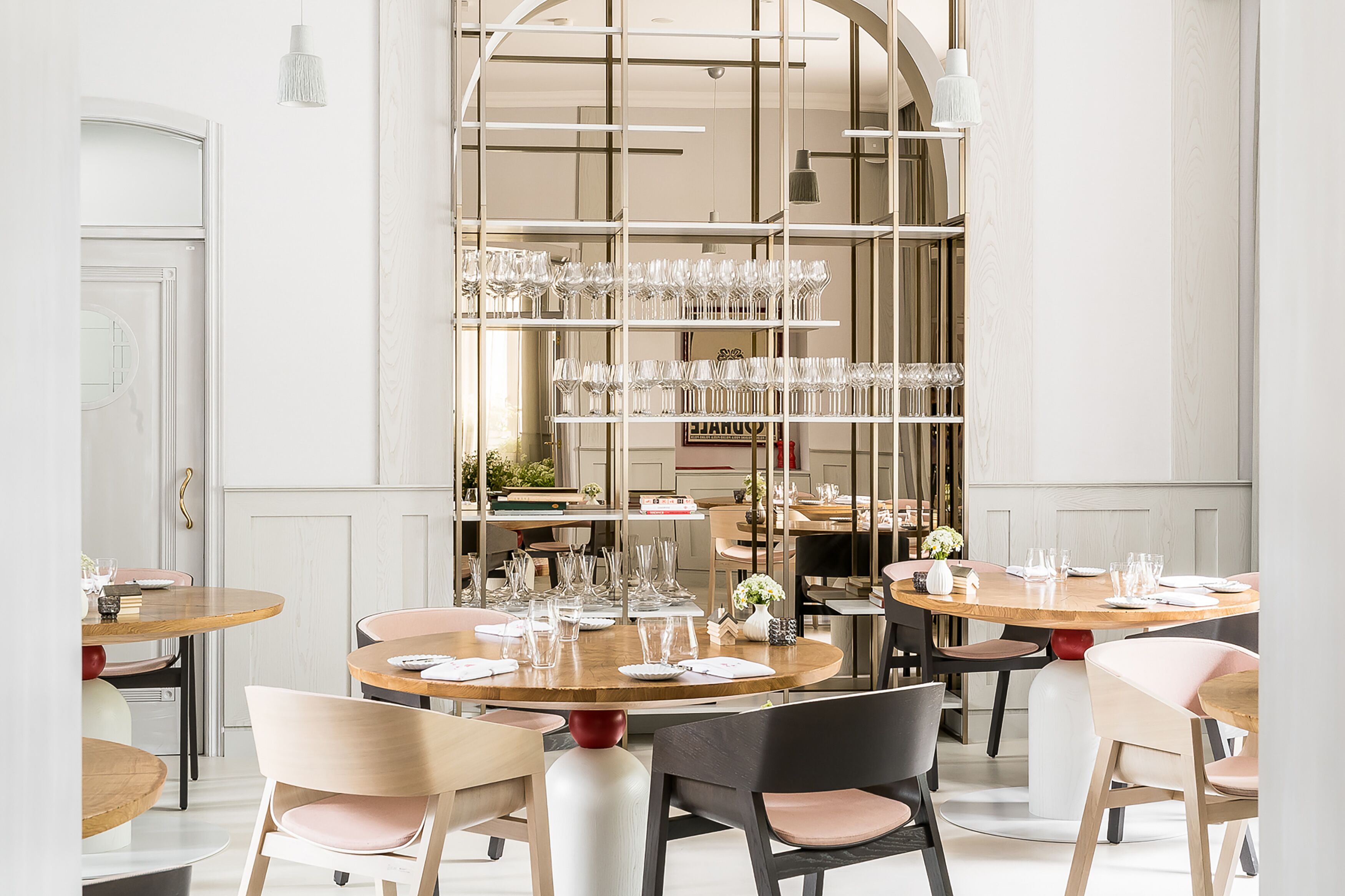A restaurant with round tables, chairs, and a central glass display.