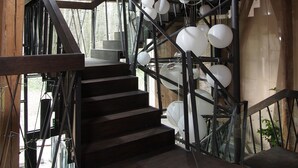 A wooden staircase with a metal railing and hanging spherical lights. - Młyn Klekotki spa resort (Gmina Godkowo)