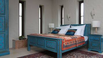 Un dormitorio con cama, mesitas de noche, cómoda y ventana.