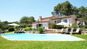 A house with a swimming pool, outdoor seating, and a garden. - Charming 5 bedroom, 3 bathroom Villa in gated domain near Valbonne with sea view (Opio)