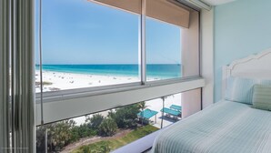 Un dormitorio con un amplio ventanal con vistas a la playa.