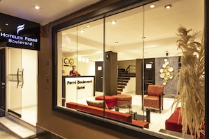 L’intérieur d’un hôtel, avec un comptoir d’accueil, un espace salon et un escalier.