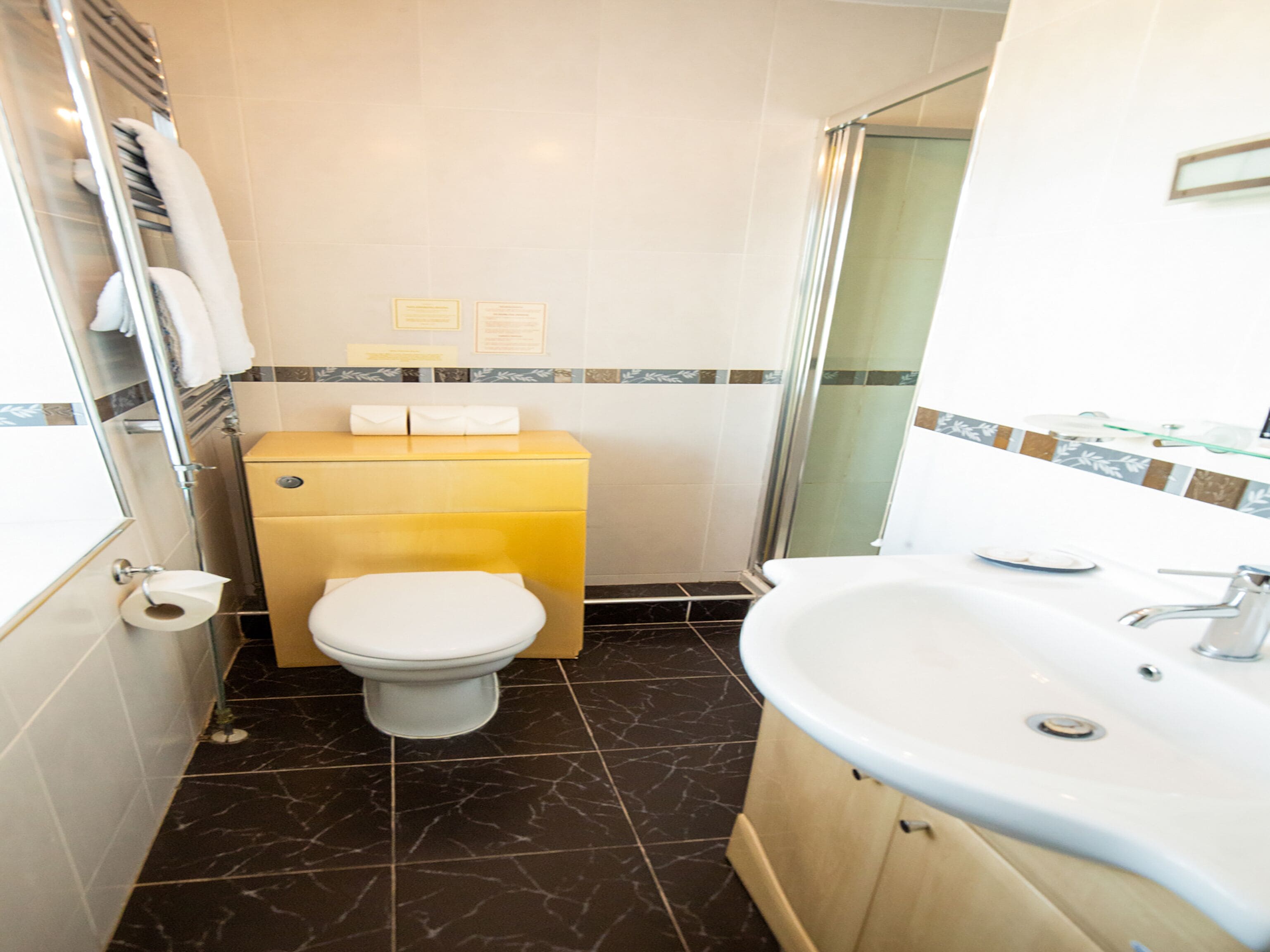 A bathroom with a toilet, sink, and shower area.