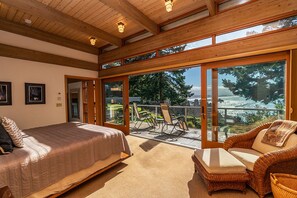 A bedroom with a bed, a sofa, and a balcony with a view of the outdoors. - Sanctuary House - Architectural Gem w/ Ocean Views! (Trinidad)
