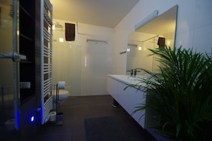 A modern bathroom with a toilet, sink, and shower area.