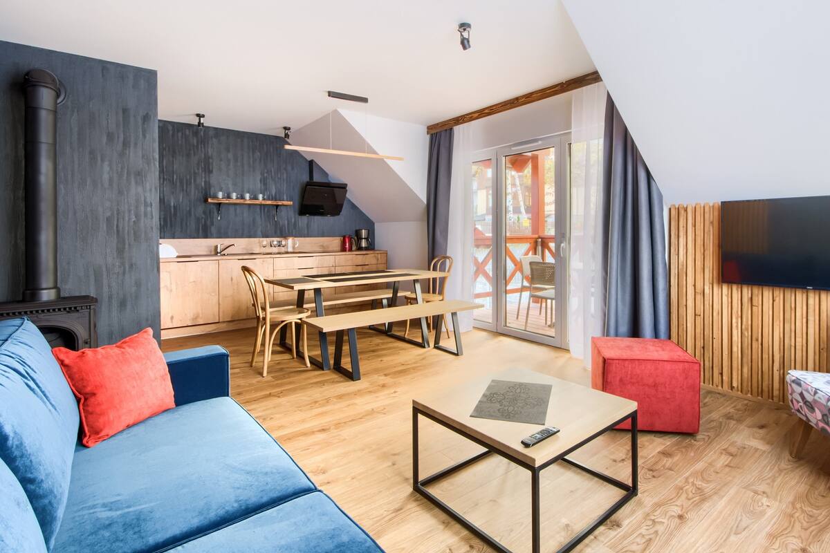 Een moderne leefruimte met een slaapkamer op een entresol, een eethoek en een keuken.