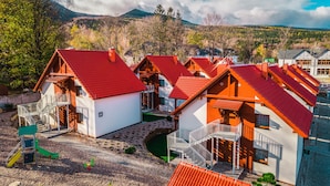 Un ensemble de maisons aux toits rouges, aux murs blancs et dotées d’un terrain de jeux.