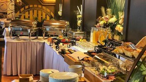 Montaje de bufé con varias estaciones de comida, que incluye una parrilla, ensaladas y una exhibición de frutas.