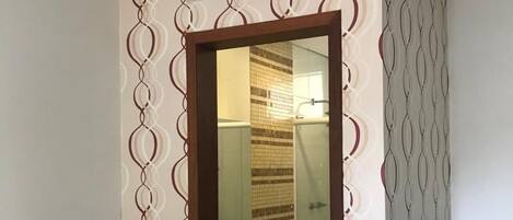 Ein Hotelzimmer mit einem Bett, einem Badezimmer inklusive Waschbecken und einer an der Wand befestigten Klimaanlage.