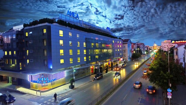 Un hôtel à étages, avec une enseigne bien visible sur le toit et une façade bien éclairée.