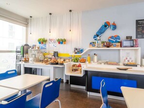 Un café moderne avec un comptoir, un espace salon et une variété de produits alimentaires exposés.