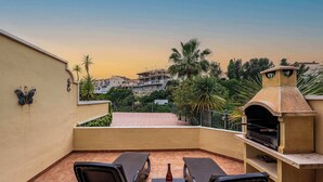 A rooftop terrace with two lounge chairs, a table, and a barbecue grill. - Jardines de Burriana 15 (Nerja)