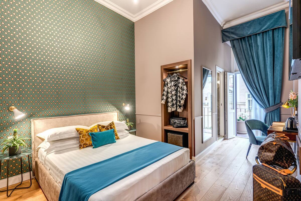 A bedroom with a bed, a wardrobe, a desk, and a chair.