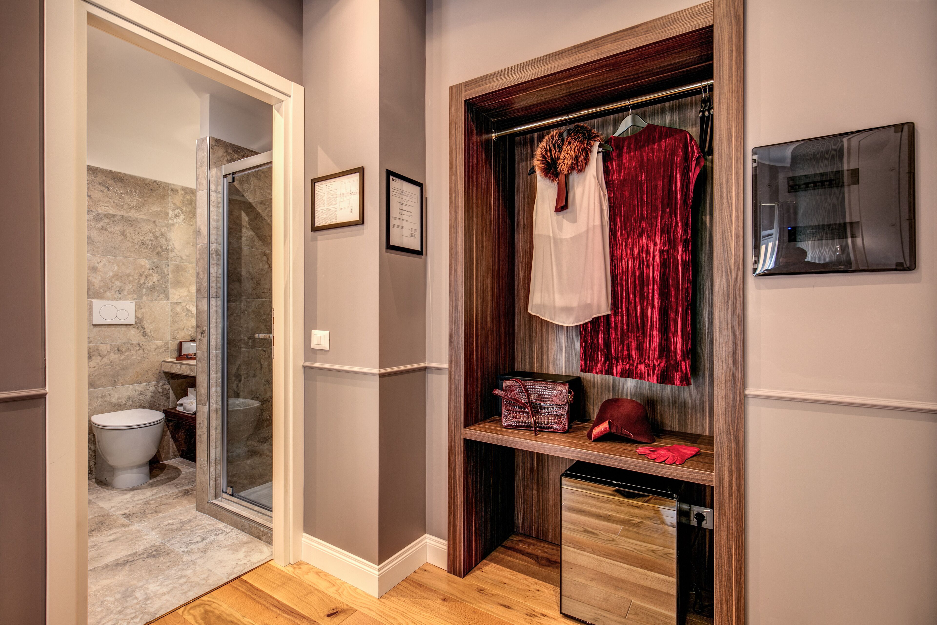A bathroom with a glass shower door, a toilet, and a vanity with a mirror.