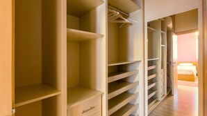 A walk-in closet with multiple shelves and hanging space. - Yiolanda - 2BR - City Center (Larnaca)