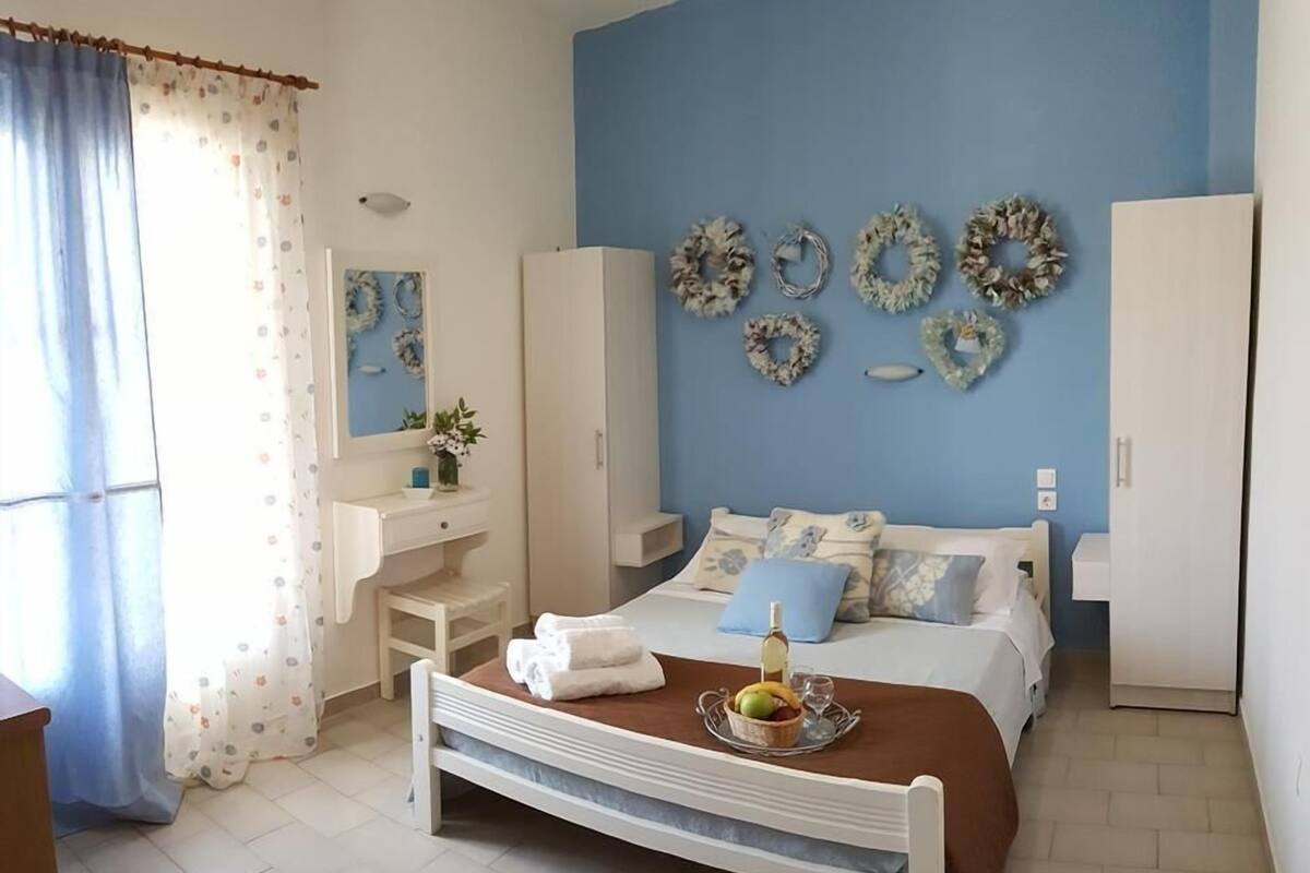 Un dormitorio con cama, cómoda, tocador y pared decorada con coronas.