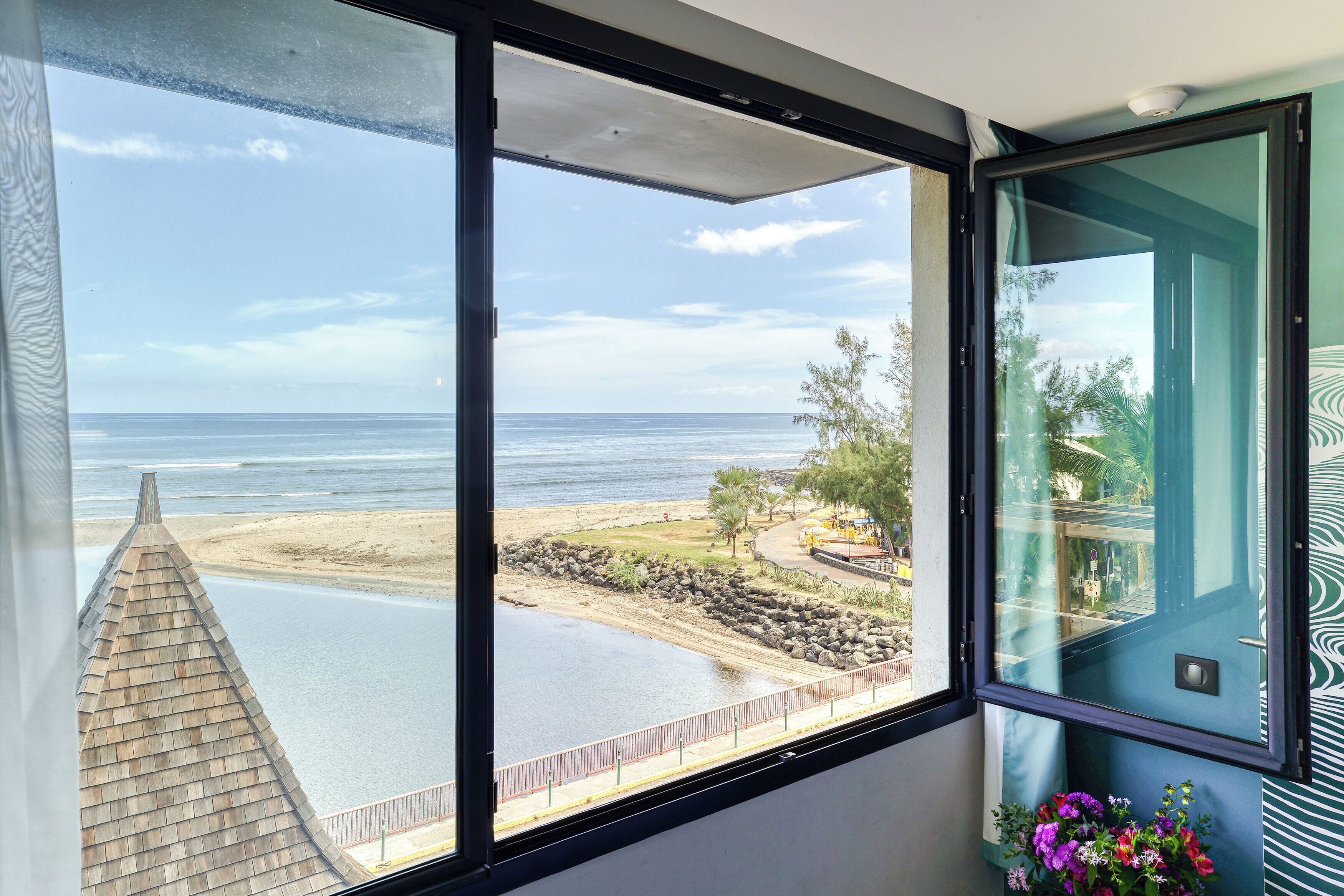 A view from a balcony overlooking a beach with a clear sky.