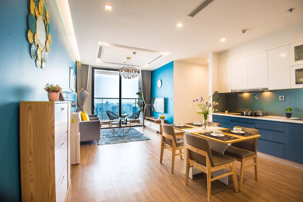 Un appartement moderne comprenant un coin repas, une cuisine et offrant une vue sur la ville.
