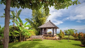 A gazebo with a tiled roof, surrounded by lush greenery and a well-maintained lawn. - ☀Sunset☀ Beachfront Dreamvilla Lovina with pool (Lovina)