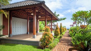 A covered outdoor area with a brick wall, wooden pillars, and a tiled roof. - ☀Sunset☀ Beachfront Dreamvilla Lovina with pool (Lovina)