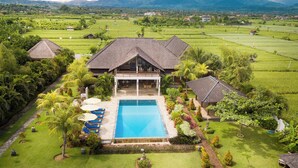 A large house with a swimming pool, surrounded by lush greenery and fields. - ☀Sunset☀ Beachfront Dreamvilla Lovina with pool (Lovina)
