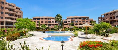 A resort with a central pool, multiple buildings, and landscaped gardens.