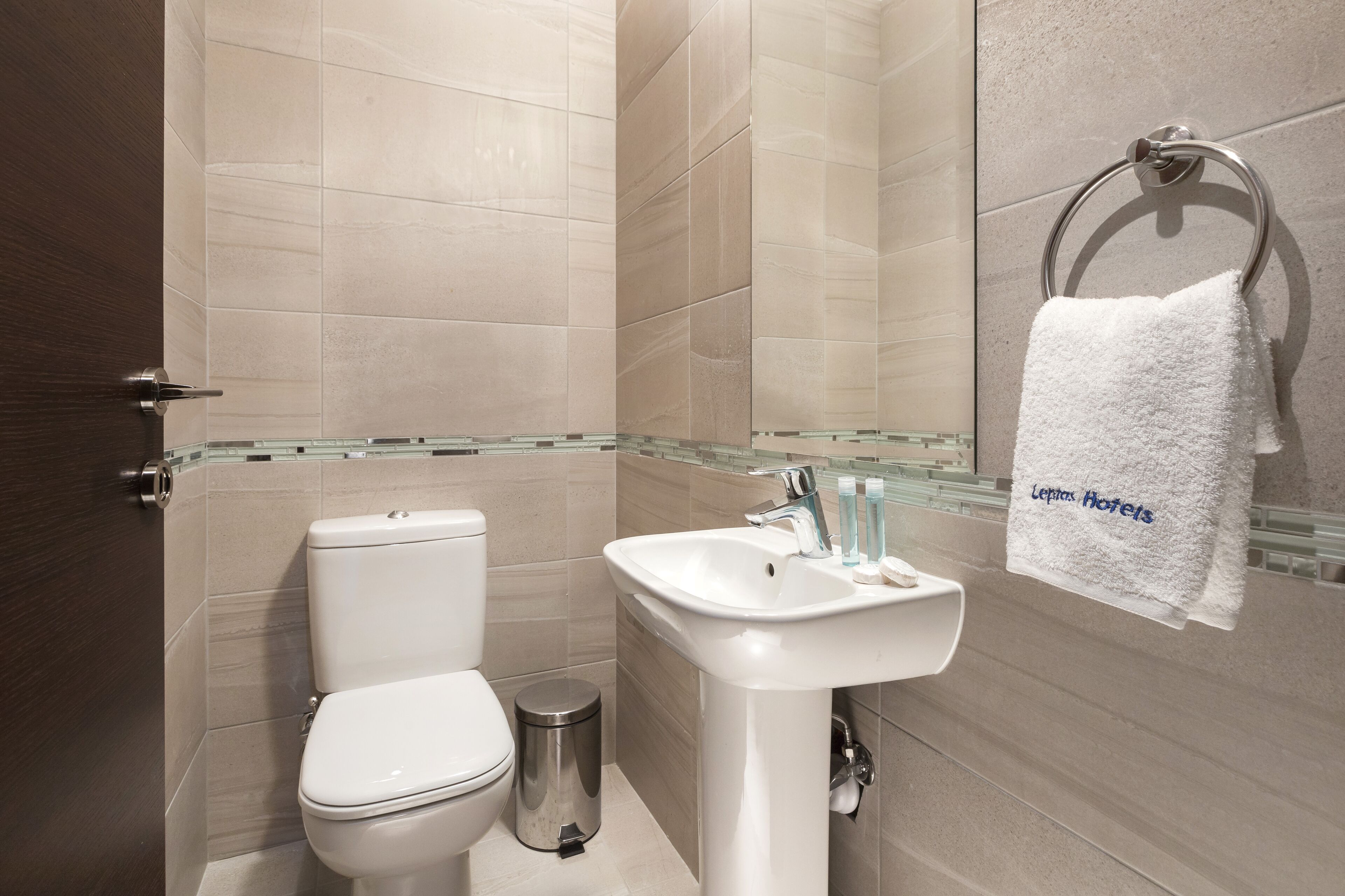 Une salle de bain moderne équipée de toilettes, d’un lavabo et d’une douche à parois en verre.