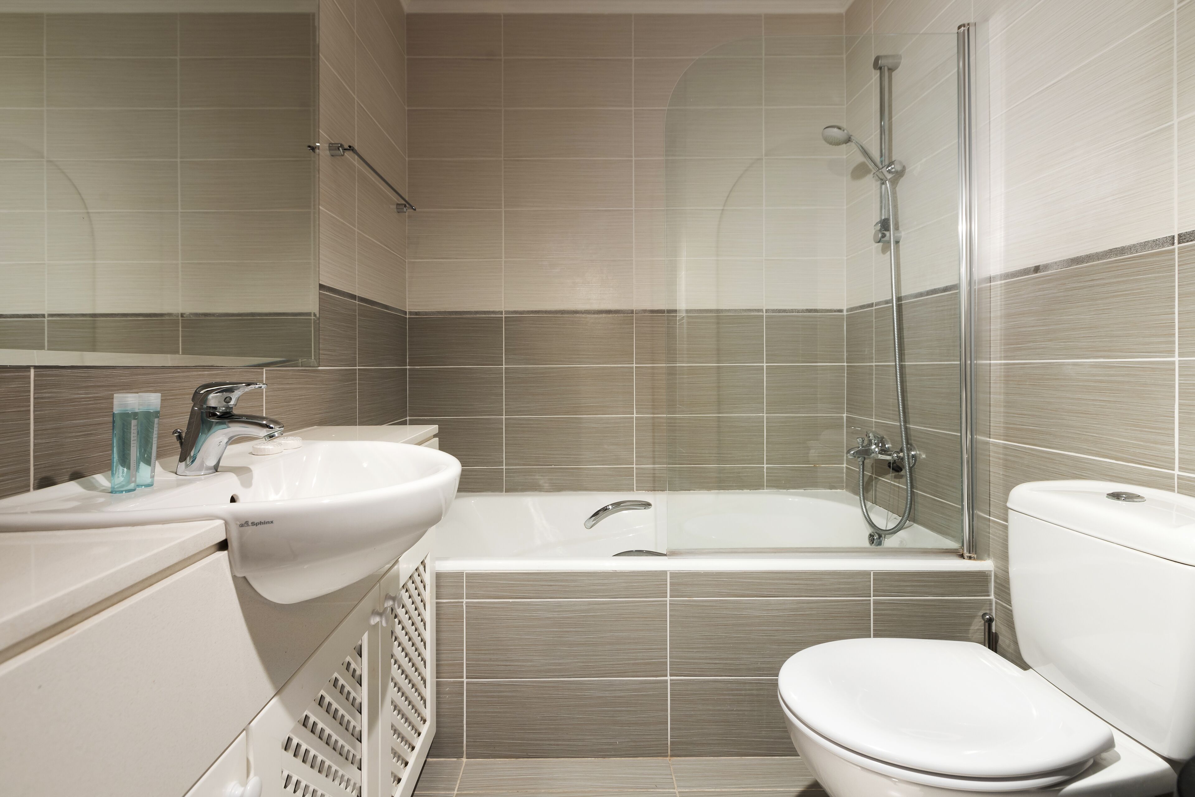 A modern bathroom with a bathtub, toilet, sink, and shower.