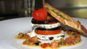 A dish with layered ingredients and a piece of bread on a white plate. - Hotel Le Montloire (Montlouis-sur-Loire)