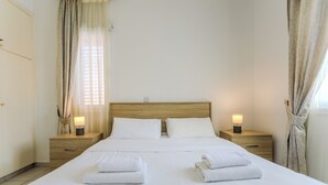 Un lit bien fait, avec du linge de lit blanc et deux tables de chevet avec des lampes.