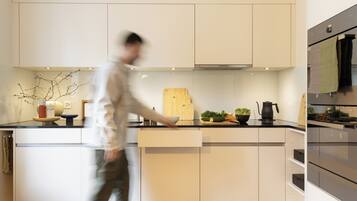 A modern kitchen with white cabinetry, a central island, and a built-in oven.