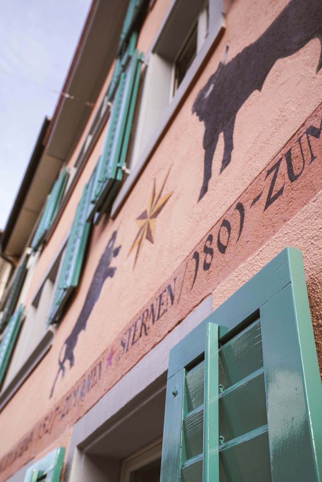 A building facade with a bull and star emblem, and the text "Sternen 1801-2011".