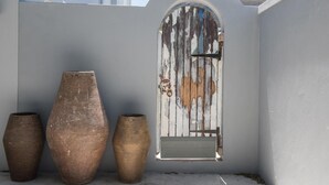 A white wall with a large arched window and three large vases. - The Whale on Main B&B (Hermanus)